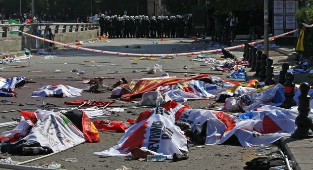 Turkish riot police forces secure the site of twin explosions. Victims' bodies are covered with banners and flags, Ankara, October 10, 2015.