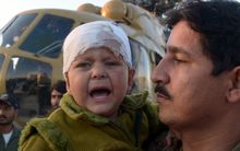 A Pakistani army officer carries a child injured in the earthquake.