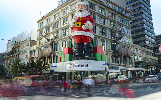 A giant Santa on Queen Street overlooks shoppers crossing the road in the Auckland Central City.