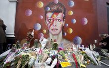 Floral tributes are left beneath a mural of David Bowie painted by Australian street artist James Cochran, aka Jimmy C, in Brixton, South London.