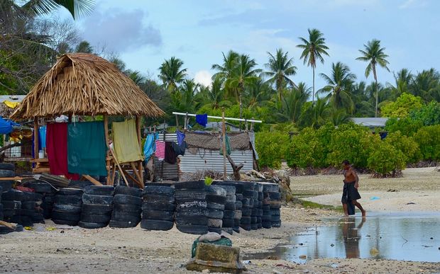 Beach and traditional hut surrounded by wall of tyres