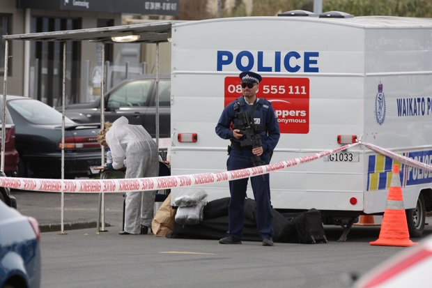 An armed police officer stands guard at the scene of a fatal shooting in Frankton, Hamilton. 