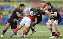 New Zealand's Tim Mikkelson is tackled sevens match against Great Britain.