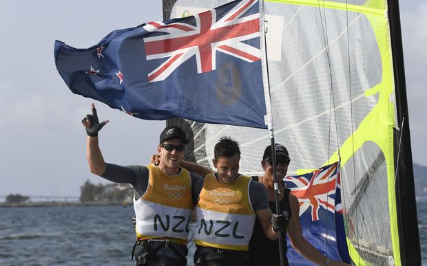 Peter Burling and Blair Tuke celebrate winning the skiff 49ers medal race at the Rio Olympics with coach Hamish Willcox.