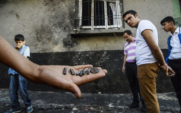 A person shows pieces of projectile near the explosion scene following a late night attack on a wedding party that left at least 30 dead in Gaziantep in southeastern Turkey near the Syrian border