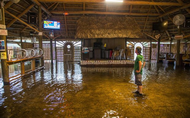 Brian Mugrage watches the weather on TV inside the Riverside Cafe flooded by the storm surge from Hurricane Hermine in Saint Marks, Florida.