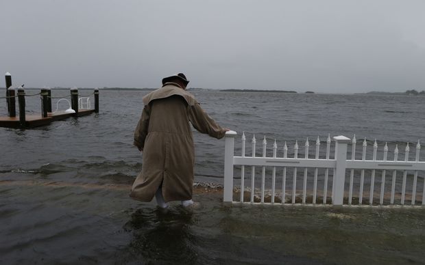 Doug LeFever inspects the seawall near his home at the Sandpiper Resort as he surveys the rising water coming from the Gulf of Mexico into his neighborhood.