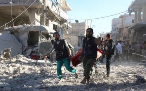 Syrian volunteers carry an injured person on a stretcher following Syrian government forces airstrikes on the rebel held neighbourhood of Heluk in Aleppo.