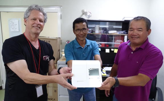 Marshall Islands Health Secretary Jack Niedenthal, left, joins Majuro hospital laboratory director Paul Lalita and Dr. Robert Maddison in showing Covid-19 test equipment 