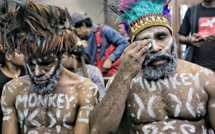 Wearing traditional headdress, Papuan human rights activists Ambrosius Mulait (left) and Dano Tabuni at the start of their trial in the Central Jakarta District Court 