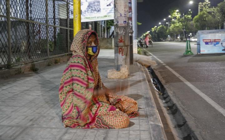 People waiting by the side of the street for relief in Dhaka, Bangladesh. Covid-19 lockdowns mean many poorer people are starving.