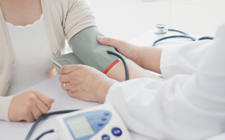 Doctor measures blood pressure of patient.
