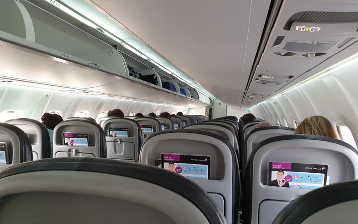 Passengers sitting at a distance from each other on an Air New Zealand flight from Christchurch to Queenstown on 14 May,