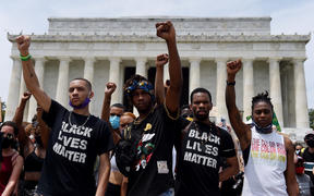 Demonstrator raise their fists at the Lincoln Memorial during a protest against police brutality and racism.