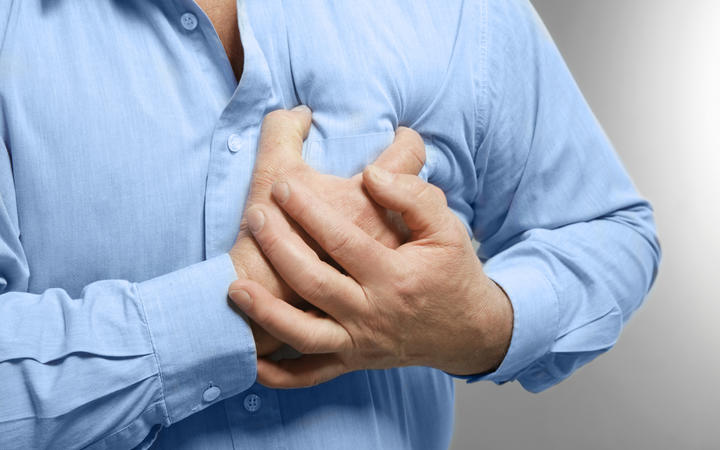 Elderly man holding hands on chest suffering from heart attack, closeup