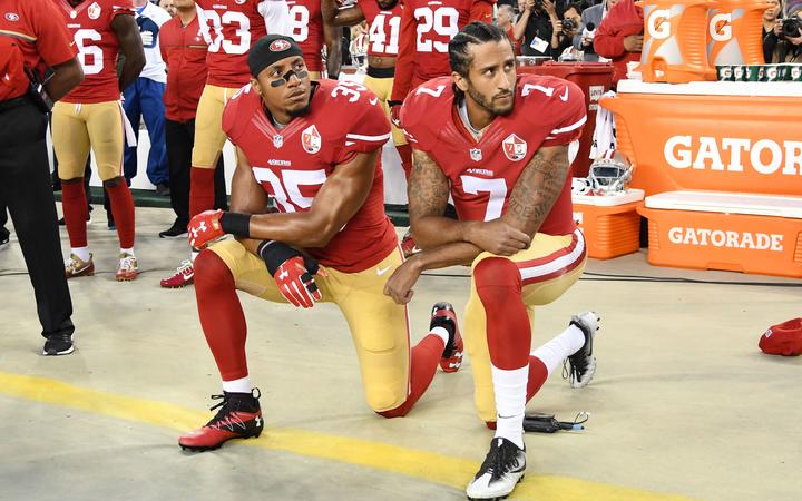 Colin Kaepernick #7 and Eric Reid #35 of the San Francisco 49ers kneel in protest during the national anthem prior to playing the Los Angeles Rams in their NFL game 2016.