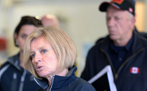 Alberta Premier Rachel Notley (left) speaks at the Fort McMurray fire department as fire chief Darby Allen looks on.