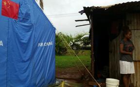 A tent helps to keep a family dry near Lautoka. Thousands are still living in crowded, makeshift shelters.