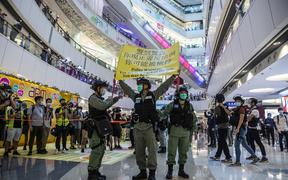 Riot police hold up a warning flag during a demonstration in a mall in Hong Kong on July 6, 2020, in response to a new national security law.