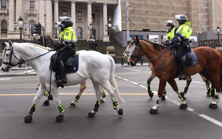 Police on horseback patrol the Melbourne central business district on August 9, 2020, as the city struggles to cope with a COVID-19 coronavirus outbreak. 