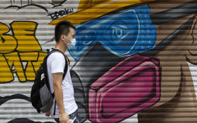 A man wearing a face mask as a precautionary measure against Covid-19 walks on a street in Hong Kong.