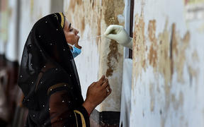 A health official takes a swab sample from a woman to test for the Covid-19 coronavirus at a testing point in Allahabad, India 