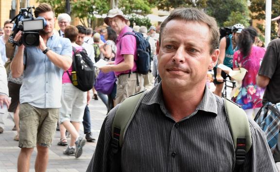 Former Australian Guantanamo Bay inmate David Hicks (R) leaves following his talks with the media at Circular Quay in Sydney on February 19, 2015. 