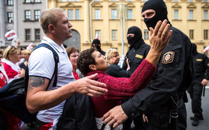 Protesters speak with Belarusian special police officers while opposition supporters rally to protest against disputed presidential elections results in Minsk on August 30, 2020