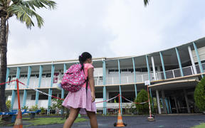 Schoolchildren wearing protective face masks arrive at the Taimoana Primary school in Papeete