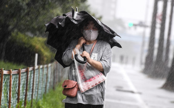 A woman walks in heavy rain as Typhoon Haishen approaches in Kagoshima, Kagoshima prefecture on September 6, 2020.