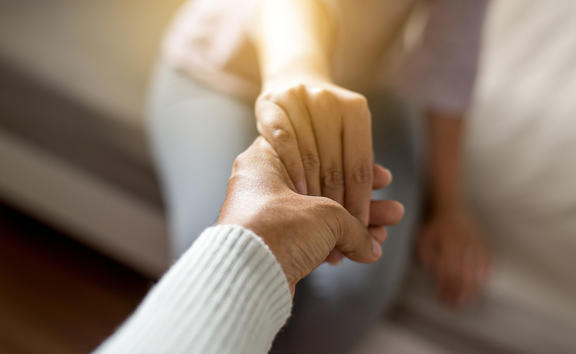 Man giving hand to depressed woman,Psychiatrist holding hands patient,Meantal health care concept,Selective focus