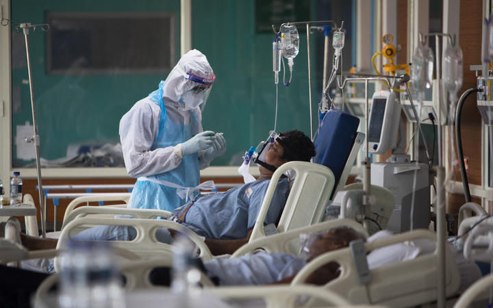 A medical staff member looks after a Covid-19 patient at the Intensive Care Unit of the Sharda Hospital, in Greater Noida in July 2020.