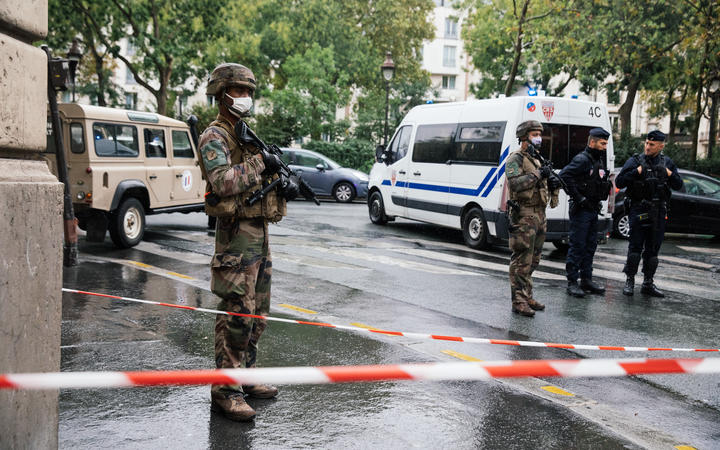 Military and police deployed on Boulevard Richard Lenoir, after two people were stabbed to death near the former premises of Charlie Hebdo. 