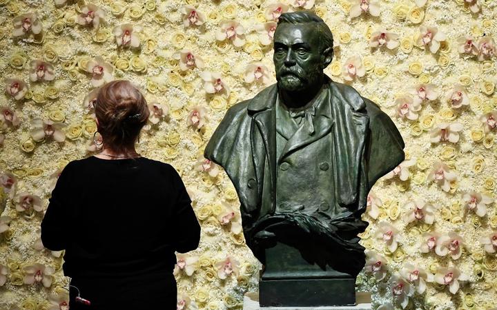 (FILES) In this file photo taken on December 10, 2019 a visitor stands in front of a bust of the Nobel Prize founder, Alfred Nobel prior the Nobel awards ceremony at the Concert Hall in Stockholm, Sweden. 