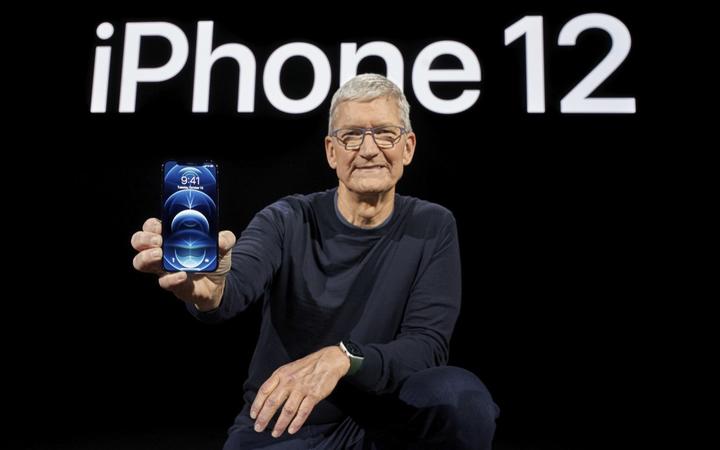 In this photo released by Apple, Apple CEO Tim Cook holds up the all-new iPhone 12 Pro.