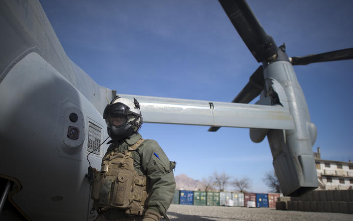 A Marine corps helicopter crew member waits as a helicopter lands at Musa Qala District centre base in Helmand province on January 27, 2011.