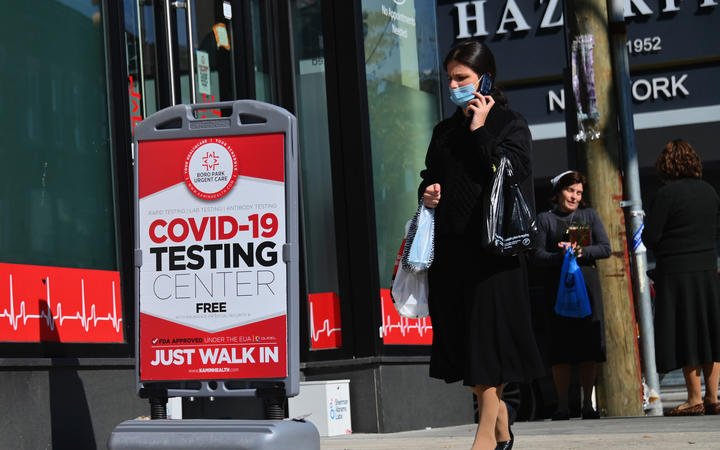 A person walks past a Covid-19 Testing Center in the Borough Park section of Brooklyn, one of the five boroughs of New York City on 9 October 2020. 