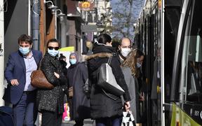 People wearing protective face masks as a measure against the spread of the Covid-19 (novel coronavirus) pandemic, take a tramway on October 22, 2020 in a street of Saint-Etienne, central eastern France. 