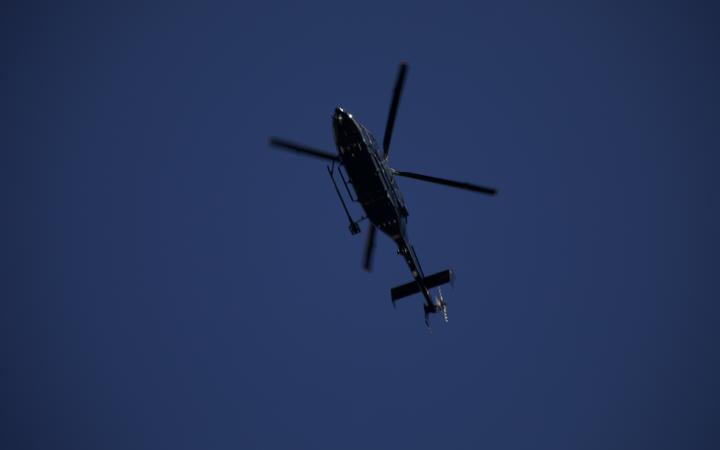 A police Eagle helicopter over the scene in Massey, Auckland.