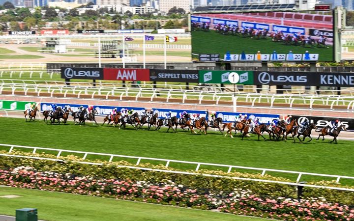 This handout photo taken and received from Racing Photos on November 3, 2020 shows the horses racing in front of empty grandstands in the Melbourne Cup at the Flemington Racecourse in Melbourne.