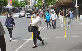 People in Queen Street Auckland, wearing masks.