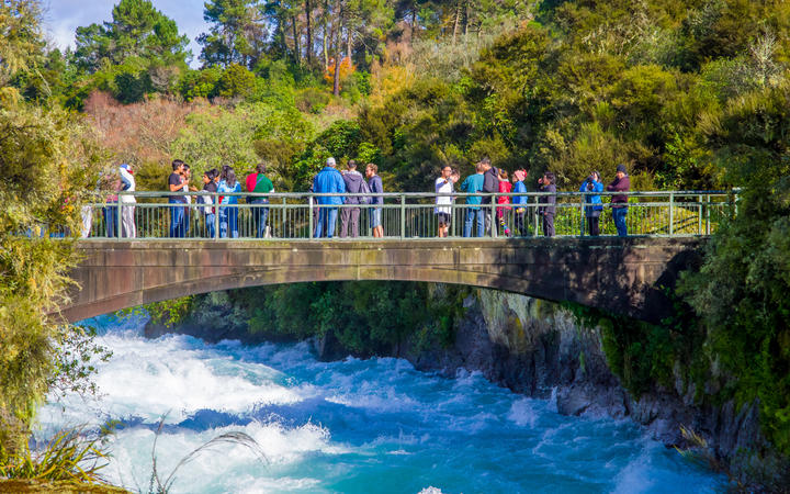 A crowd of people enjoying the view of Huka Falls on the Waikato River near Taupō.