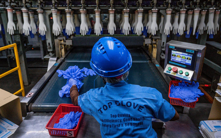 A worker inspects disposable gloves at the Top Glove factory in Shah Alam on the outskirts of Kuala Lumpur on August 26, 2020.