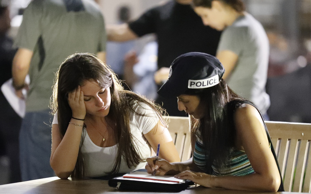 An Israeli policewoman (right) interviews a witness at the site of a shooting attack in Tel Aviv.