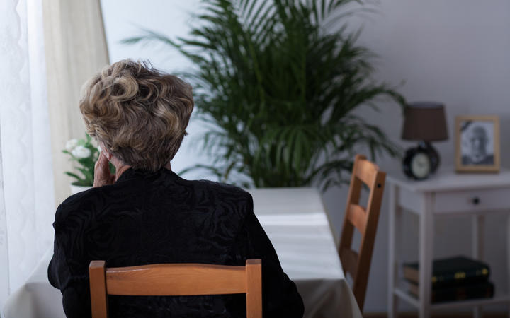Depressed elderly widow sitting alone at home