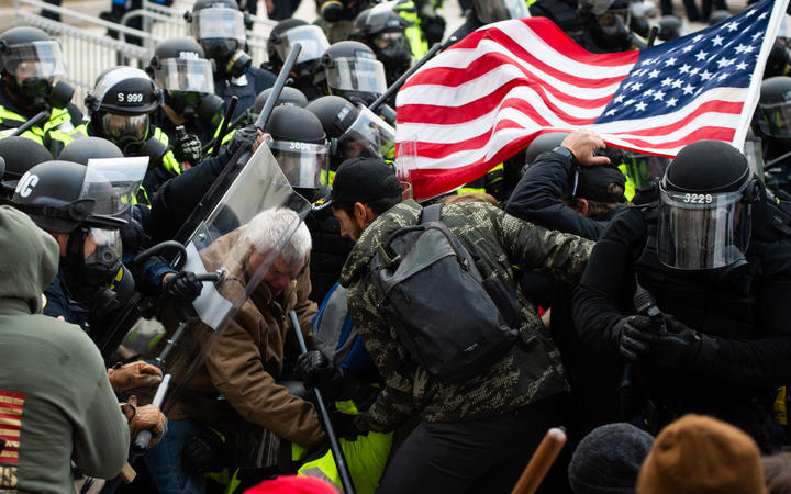 Supporters of US President Donald Trump fight with riot police outside the Capitol building on 6 January 2021 in Washington DC. 