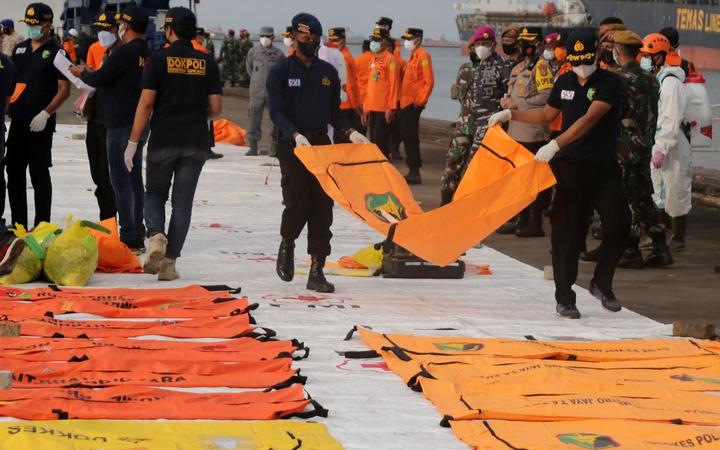 JAKARTA, INDONESIA - JANUARY 11: Navy members and rescue (SAR) officers bring body parts of victims and debris of Sriwijaya Air SJ 182, found 23 meters deep in the sea, for inspection at the crisis center at Tanjung Priok Port, Jakarta.