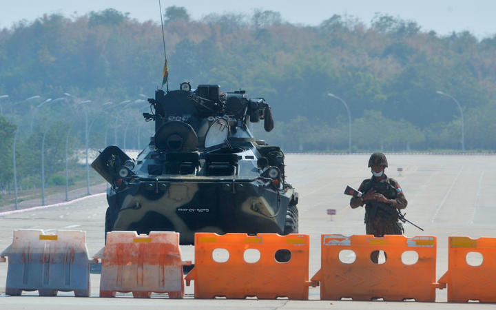 A soldier stands guard on a blockaded road to Myanmar's parliament in Naypyidaw on 1 February 2021, after the military seized power in a coup against the elected government of NLD leader Aung San Suu Kyi.