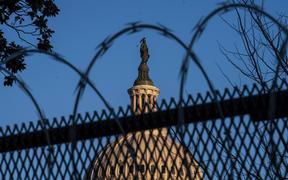 The exterior of the U.S. Capitol building is seen through barbed wire fencing at sunrise on February 8, 2021 in Washington, DC. 