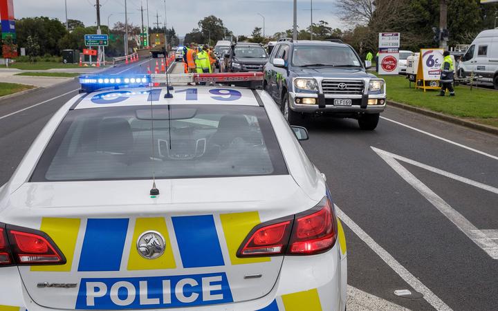 Police and military personnel check vehicles leaving the city at a COVID-19 check point setup at the southern boundary in Auckland on August 14, 2020. 